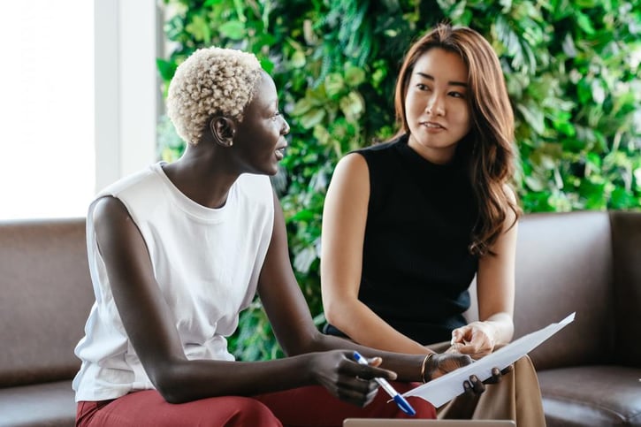 Twee vrouwen zitten te praten op de bank